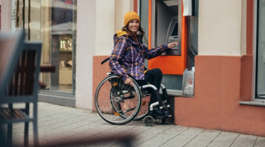 Vrouw in rolstoel kan pint zelfstandig geld bij geldautomaat