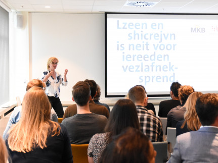 Vrouw geeft presentatie over toegankelijkheid op bijeenkomst VvV